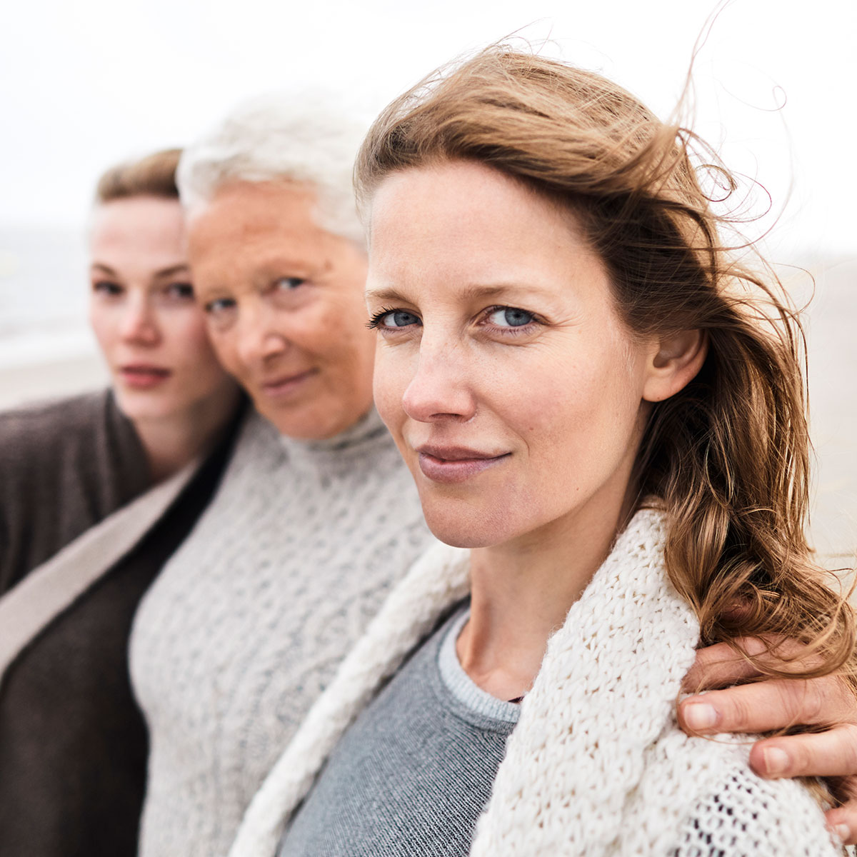 Frauen in drei Generationen stehen am Strand