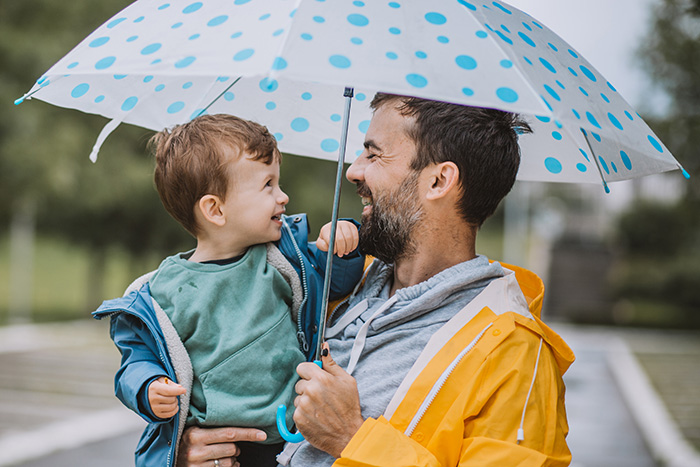 Vater und Sohn unter Regenschirm