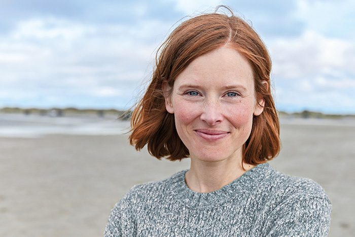 Rothaarige Frau grinst in die Kamera