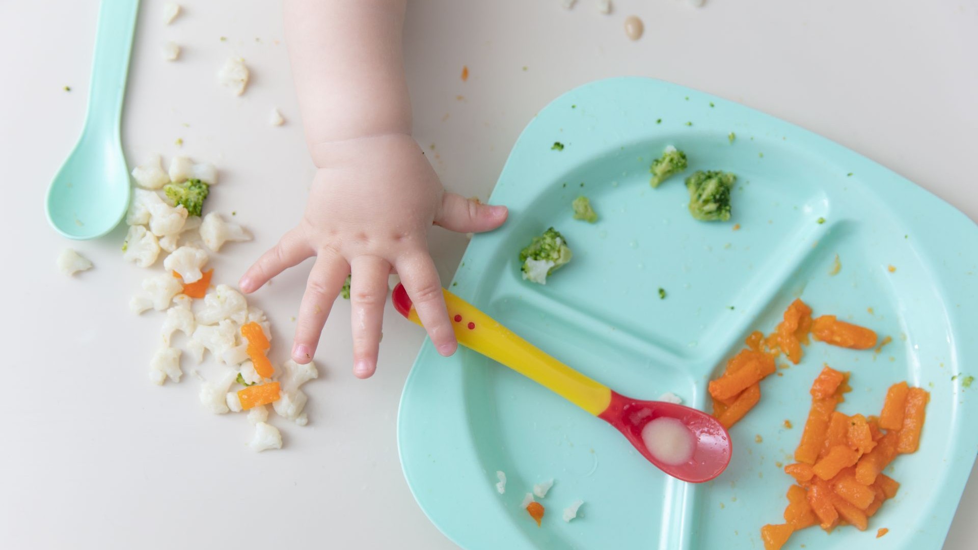 Kind greift mit Hand zum Gemüse