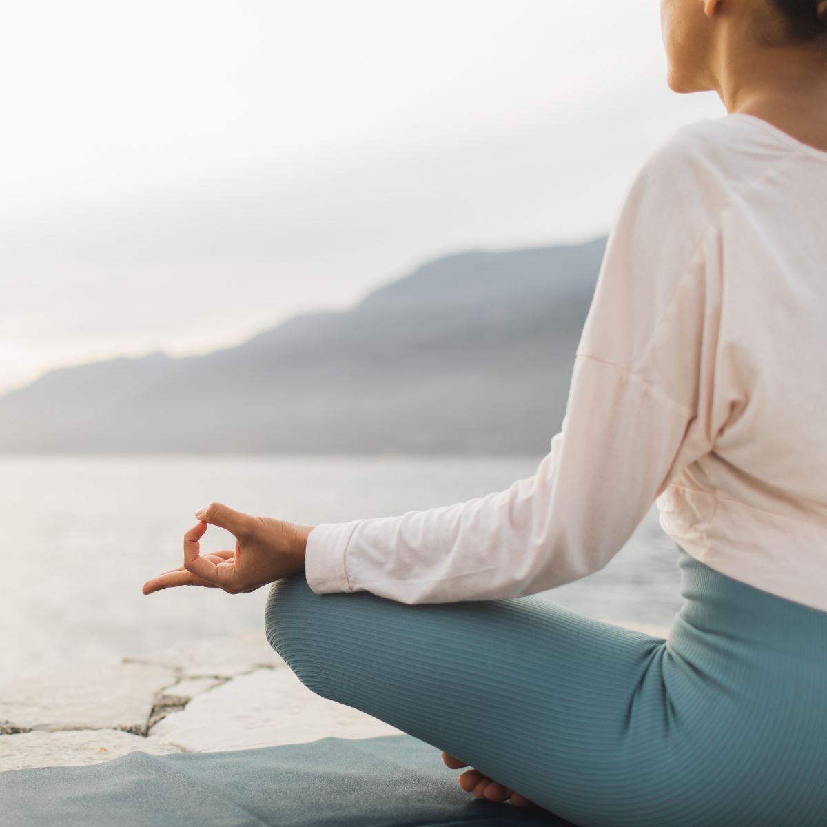 Frau praktiziert Yoga mit Blick auf das Meer