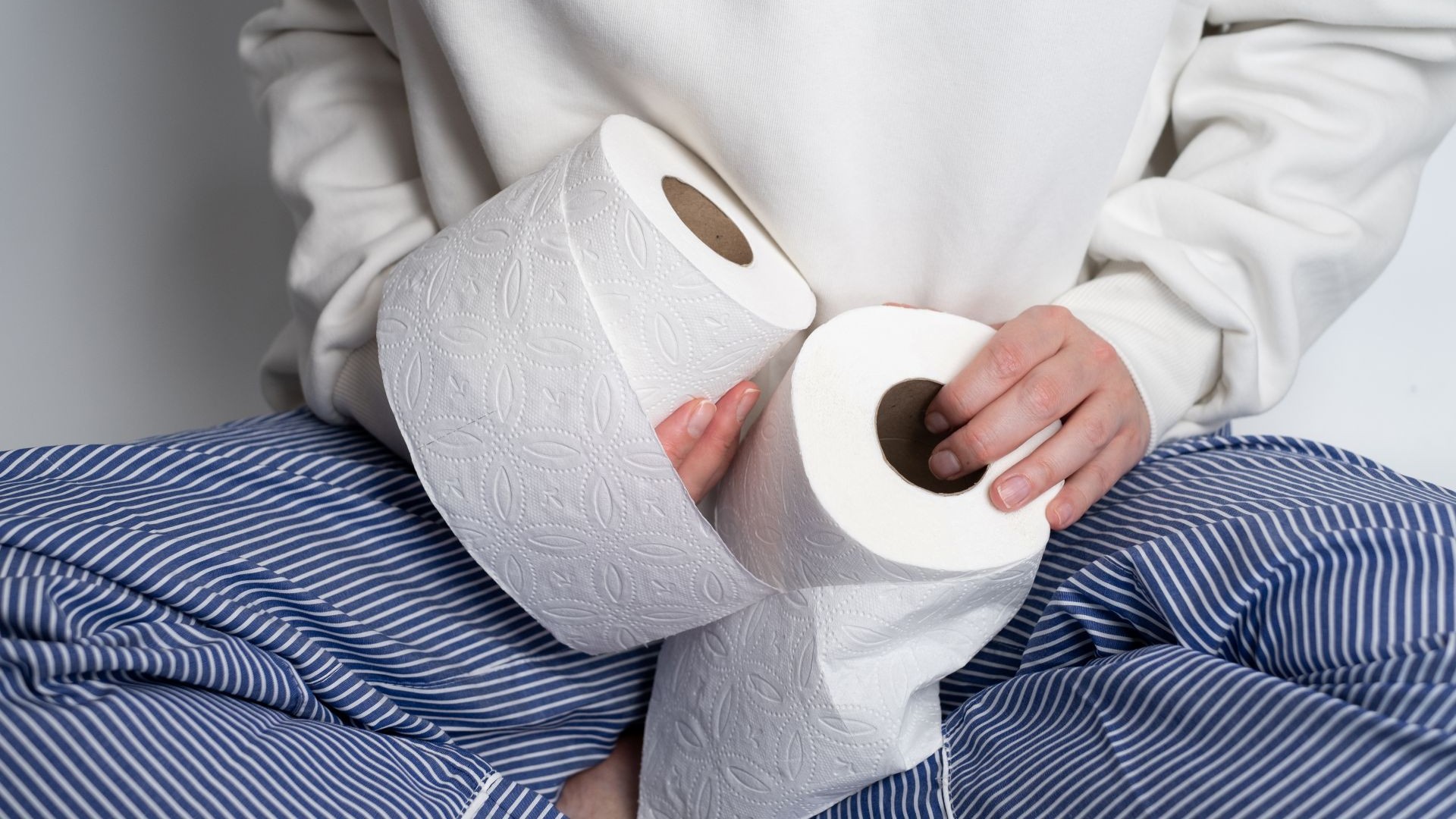 Frau hält Toilettenpapier in den Händen